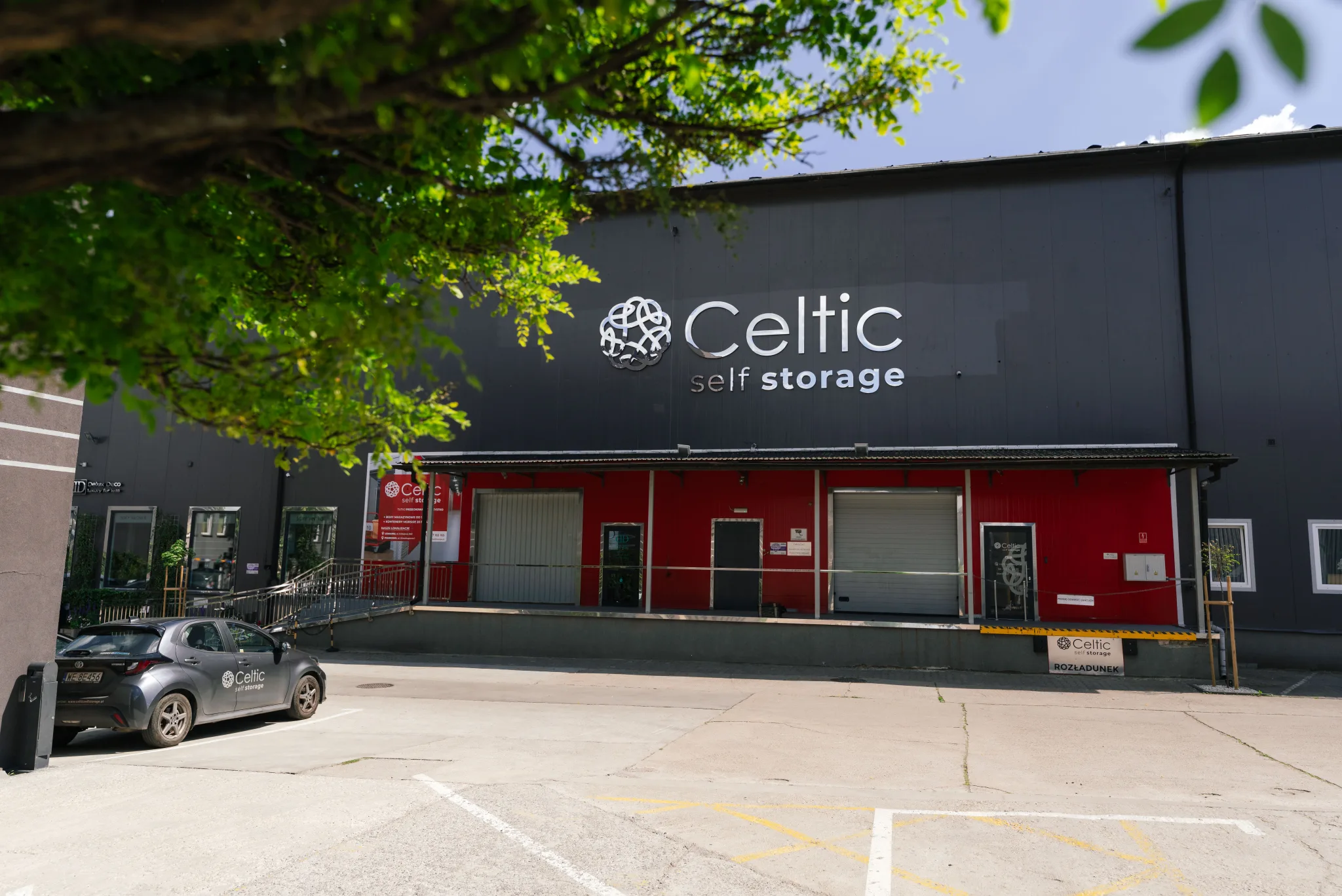 Fasada budynku Celtic Self Storage Piaseczno z logo, wejściem i parkingiem